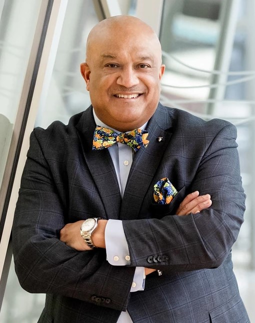 Victor Cardwell, Principal and Management-side Employment Lawyer at Woods Rogers seen posing for a photo by leaning on a big window
